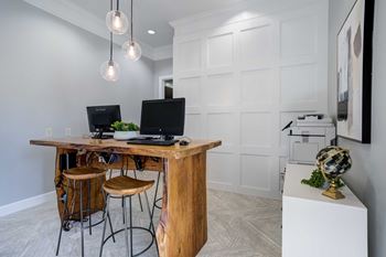 A home office with a wooden desk and two computer monitors